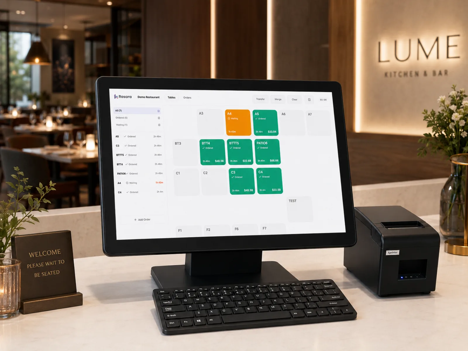 A POS terminal on the counter showing the floor view, with a receipt printer beside it